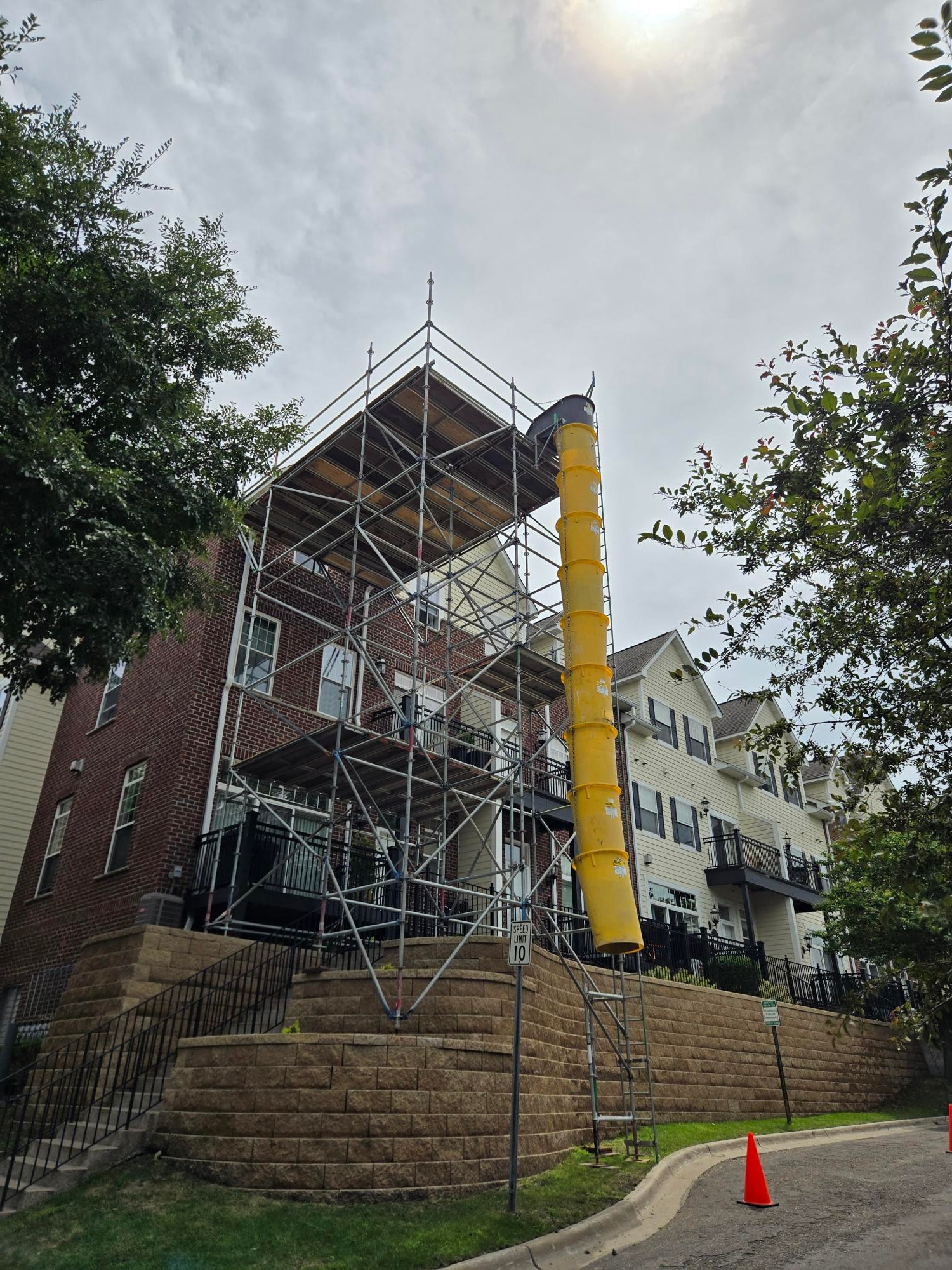 Organized job site with debris chute at 1592 Juno Ave construction project