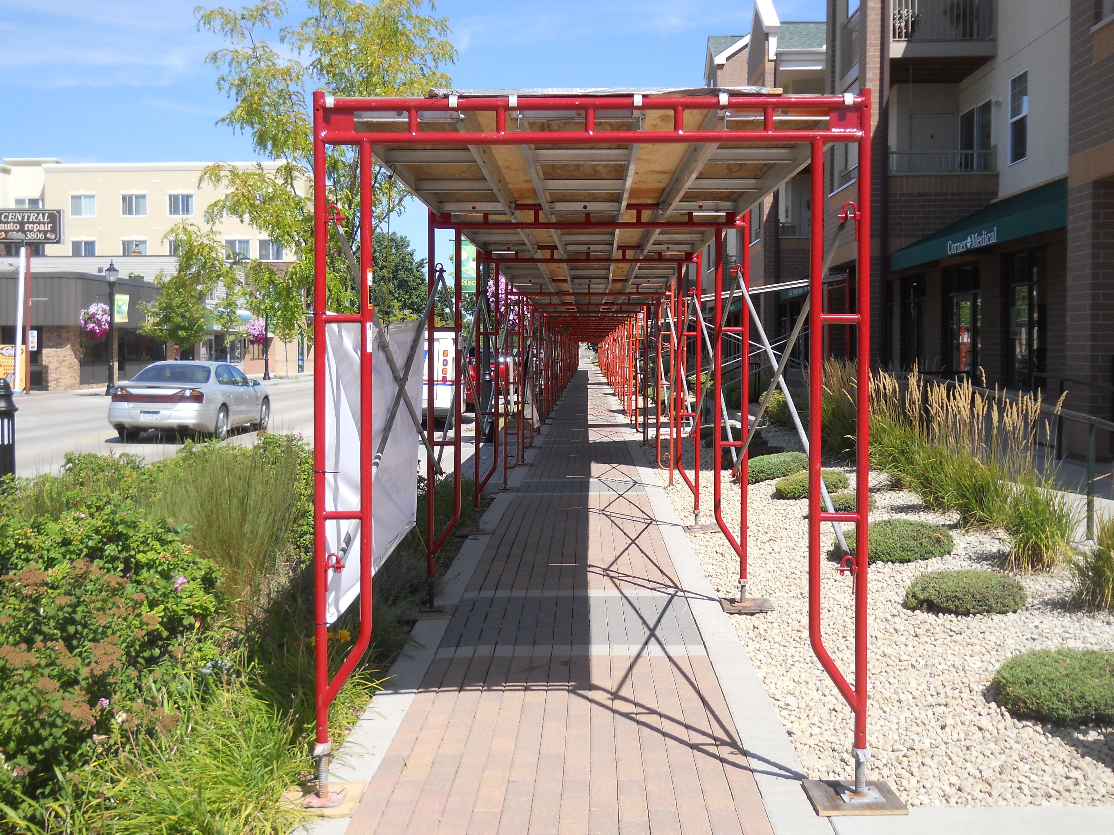 Roofline scaffold with integrated overhead and pedestrian protection