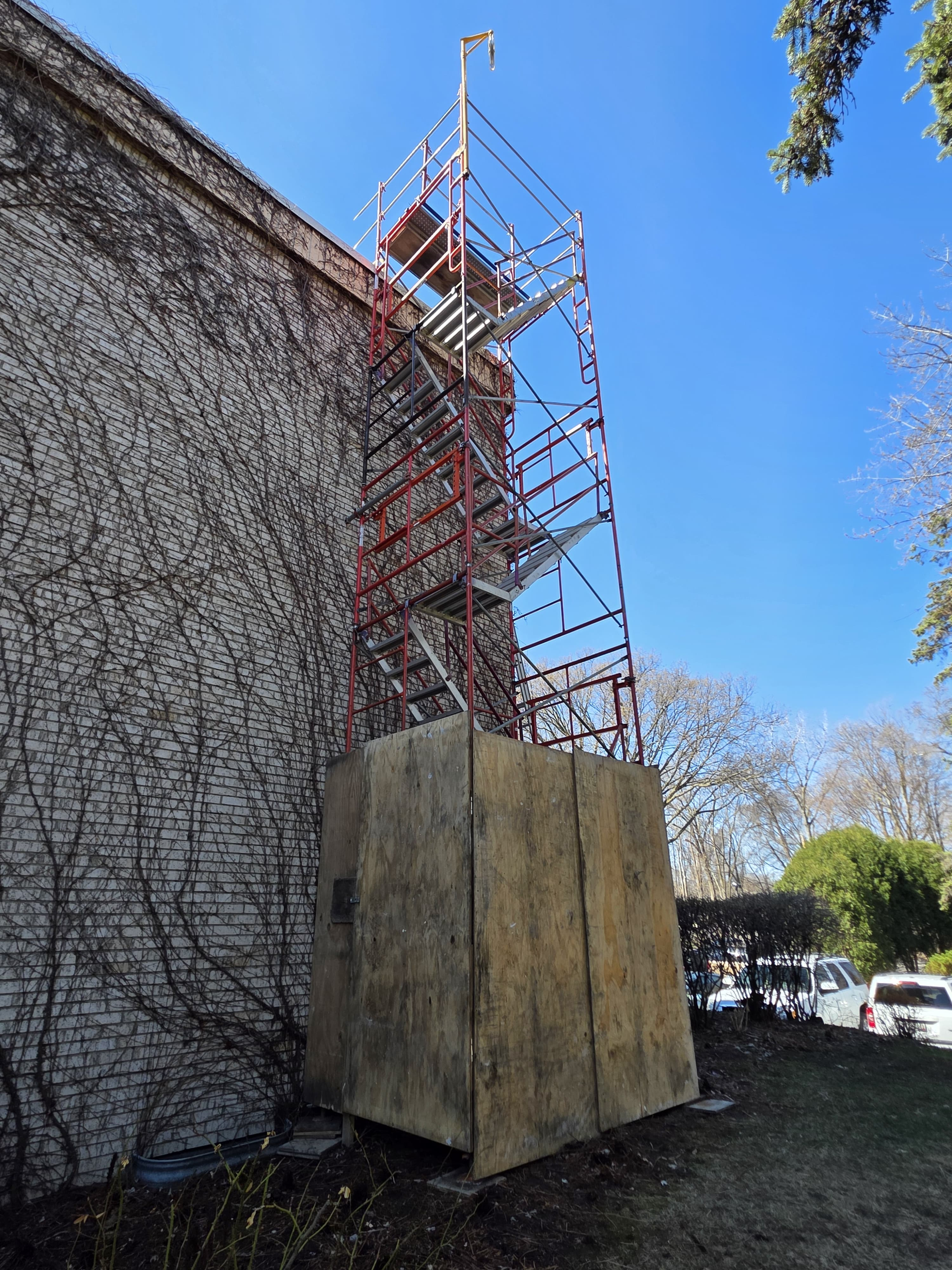 A stair tower with a plywood enclosure on the side of a building