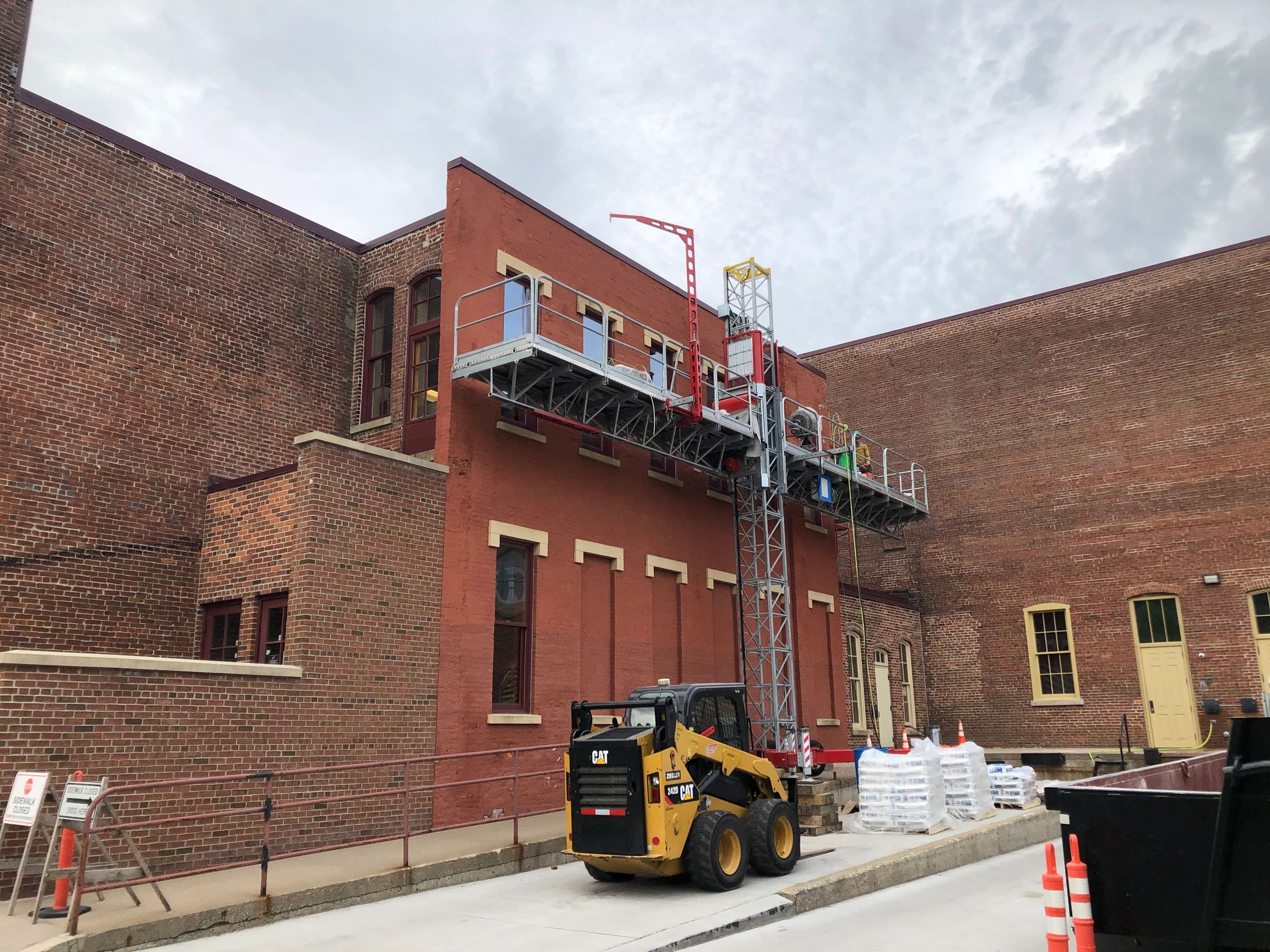 Mast climber providing access for masonry work
