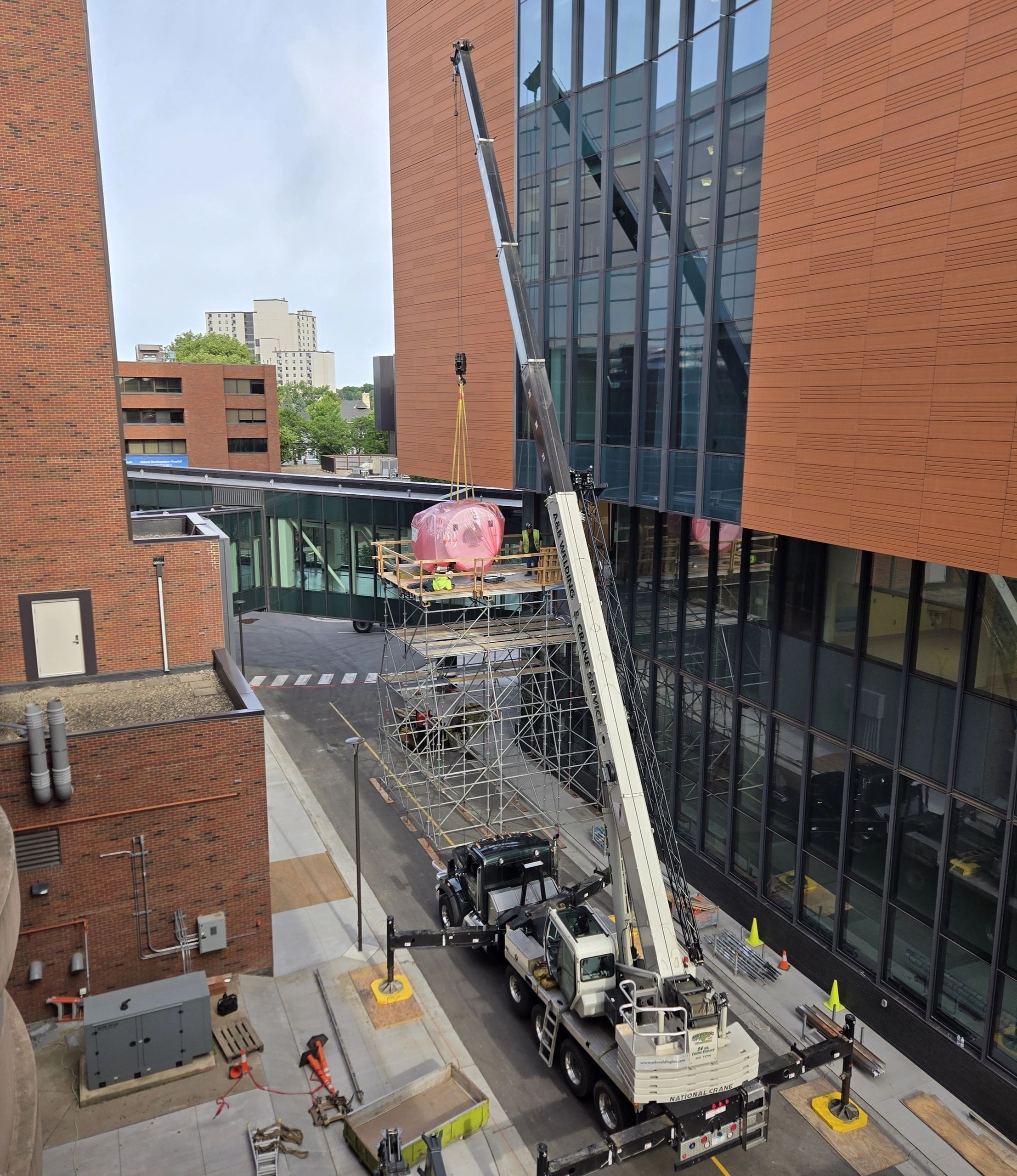 A crane landing a new MRI unit on a system scaffold platform at Abbott Northwestern Hospital in Minneapolis, MN.